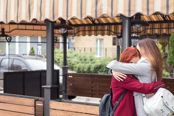 Duas adolescentes do sexo feminino abraçando no café de rua da cidade — Fotografia de Stock