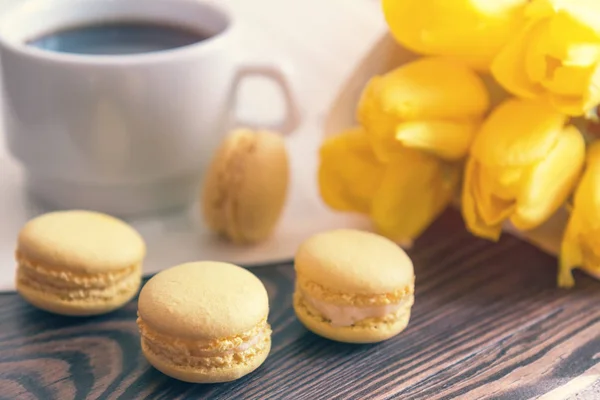 Beautiful spring music background. Cup of coffee, macaroons, yel — Stock Photo, Image