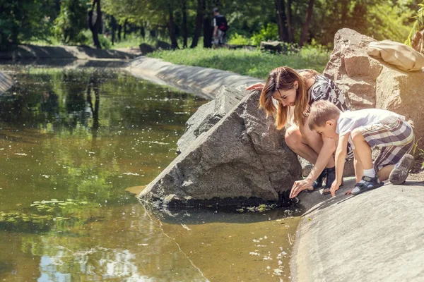 Mutlu küçük çocuk annesi şehir parkı ile oynarken bir s