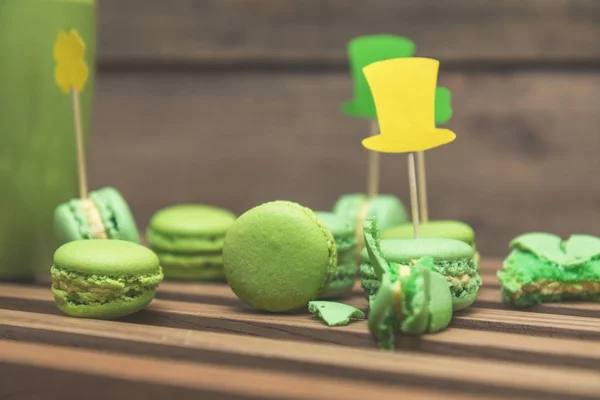 Green macaroon cookies scattered on the wooden surface — Stock Photo, Image