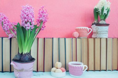 Pembe sümbül, kurabiye, çay bardak ve pil yakınındaki beyaz sümbül