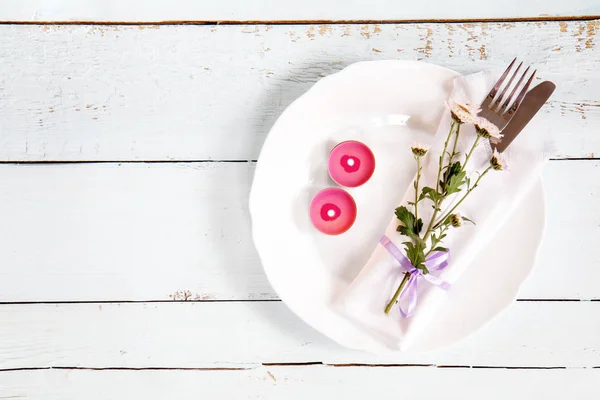 Λευκό άδειο πιάτο, ροζ λουλούδια χρυσάνθεμων, δύο ροζ κεριά, — Φωτογραφία Αρχείου