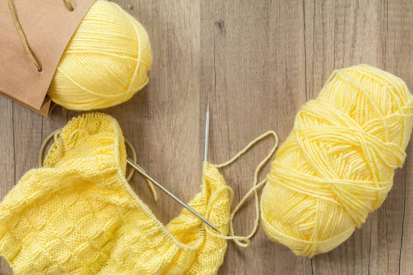 淡黄色のウールのニットと木製の表現に編み物 — ストック写真