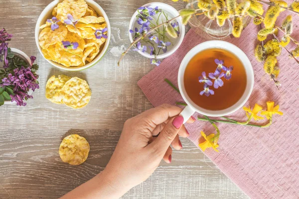 Taza de té con viola violeta, deliciosos panes de cereales nutritivos —  Fotos de Stock