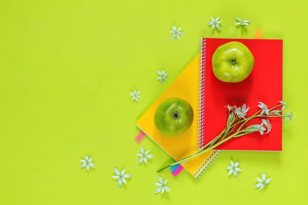 Ornithogalum et cahiers rouges et jaunes, pommes vertes — Photo