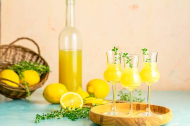Limoncello with thyme in grappas wineglass with water drops on l clipart