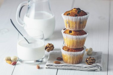 Kağıt bardakta vanilyalı karamelli kek ve beyaz bardakta süt.