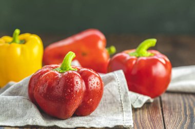 Olgun organik tatlı kırmızı ve sarı biber. Koyu ahşap masada. Kalp ve yaşam konsepti için sağlıklı yiyecek seçimi