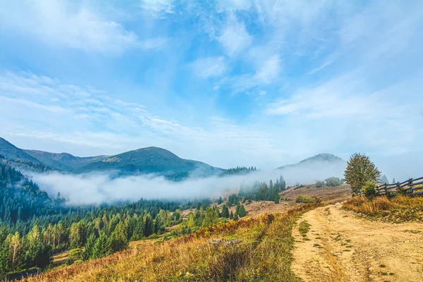 Aerial view amazing over of the Carpathian Mountains or Carpathians with Beautiful autumn landscape , sunrise, blue sky with white clouds, fog between the mountain slopes — Stock Photo, Image