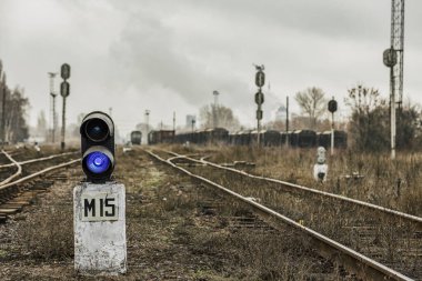 Mavi sinyali olan bir tren yolu trafik lambası. Bulanık bir arkaplanda demiryolu kavşağında Semaphore. Doğu Avrupa 'daki Altyapı Eski Demiryolu. Seçici odak.