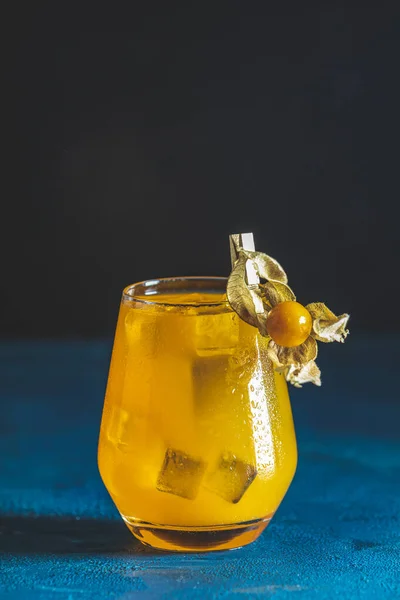 Yellow orange cocktail with tangerine and rosemary with ice in glass on dark blue concrete background , close up. Christmas and New Year holiday welcome drink. — Stock Photo, Image