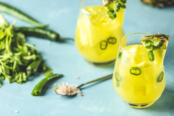 Baharatlı ananas jalapeno mezcalita ya da Cinco de Mayo için margarita ananas, kişniş, jalapeno ve Meksika damıtılmış alkollü içecekten yapılan ferahlatıcı bir kokteyl. Mavi beton yüzey.