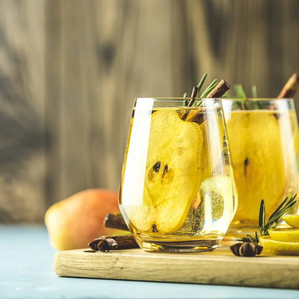 Festliche Sommergetränke, Birnengewürz-Cocktail. Heißgetränk-Cocktail für Weihnachten, Winter oder Herbst. serviert mit Zutaten auf hellblauer Oberfläche. — Stockfoto