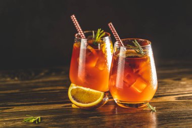 İki bardak su damlası ve portakal dilimli İtalyan aperol spreyi kokteyli. Kırmızı acı, kuru beyaz şarap, soda, kırmızı turuncu ve buzlu Milano spritzer alkollü kokteyli. Koyu arkaplan, muhteşem arka plan ışığı.