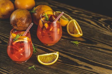 Kırmızı acı, kuru beyaz şarap, soda, kırmızı turuncu ve buzlu Milano spritzer alkollü kokteyli. Koyu tahta arkaplan, seçici odak