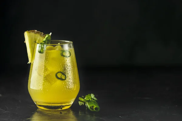 Baharatlı ananas jalapeno mezcalita veya Cinco de Mayo için margarita, siyah yüzey üzerinde ananas, kişniş, jalapeno ve Meksika damıtılmış alkollü içecekten yapılan ferahlatıcı bir kokteyl.