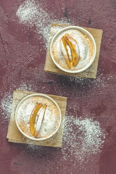 Zwei Apfelkuchen Keramischen Backformen Mit Pergament Auf Dunkelrotem Betontisch Draufsicht — Stockfoto