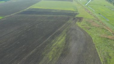Arazi iyileştirme ya da arazi ıslah konsepti, Dar sulama üzerinde uçan dron ya da çavdar ya da buğday tarlasında drenaj kanalları. Riskli tarım alanında tarımın resmedilmesi.