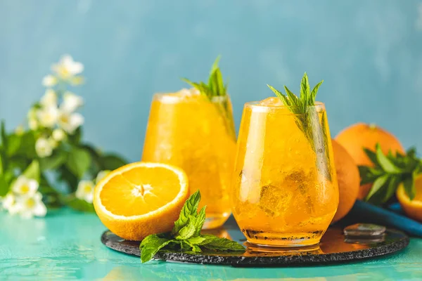 Zwei Glas Orangefarbenes Eisgetränk Mit Frischer Minze Auf Türkisfarbener Tischoberfläche — Stockfoto