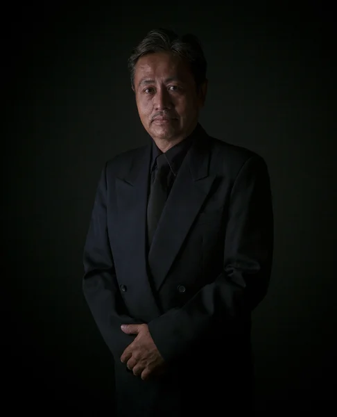 Thai senior man wearing black suit traurig emotion, portrait by — Stockfoto