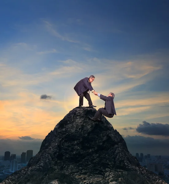 Two of asian business man helping hand to climbing up to peak of — Stock Photo, Image