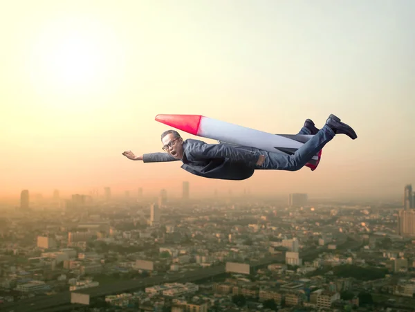 Geschäftsmann fliegt mit Rakete über Wolkenkratzer — Stockfoto