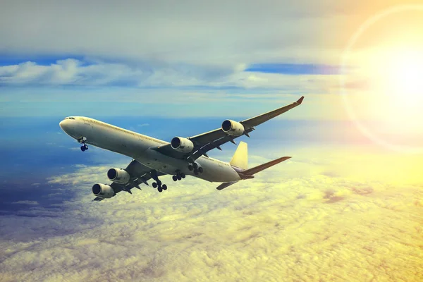 Avião aéreo voando sobre a paisagem nuvem e luz do sol atrás — Fotografia de Stock