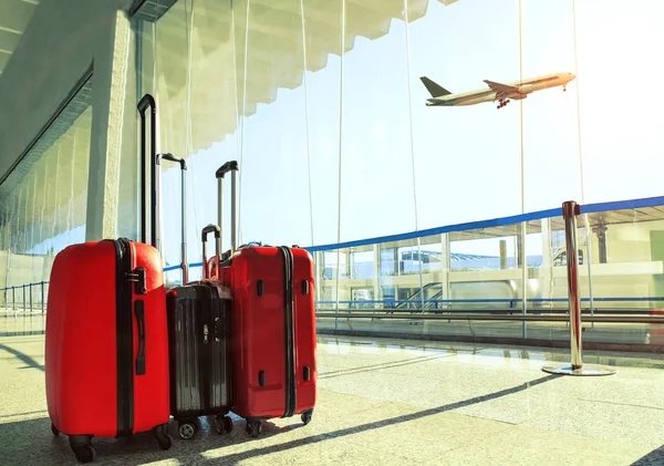 Stack of traveling luggage in airport terminal and passenger pla — Stock Photo, Image