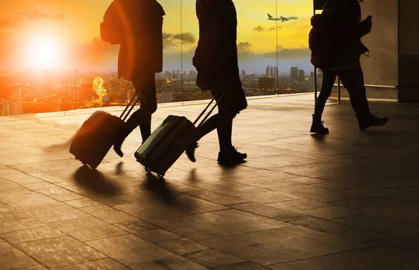 people and traveling luggage walking in airport terminal buildin