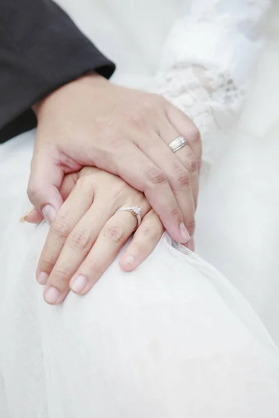 Kezét a vőlegény és a menyasszony felmelegedés gazdaságban, ahol esküvői Vilmos rin — Stock Fotó