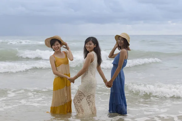 Yngre asiatisk kvinna vän avkopplande semestertid vid havet stranden h — Stockfoto