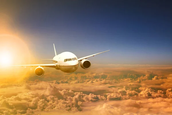 Flugzeug fliegt über Wolkenlandschaft und dahinter Sonnenlicht — Stockfoto