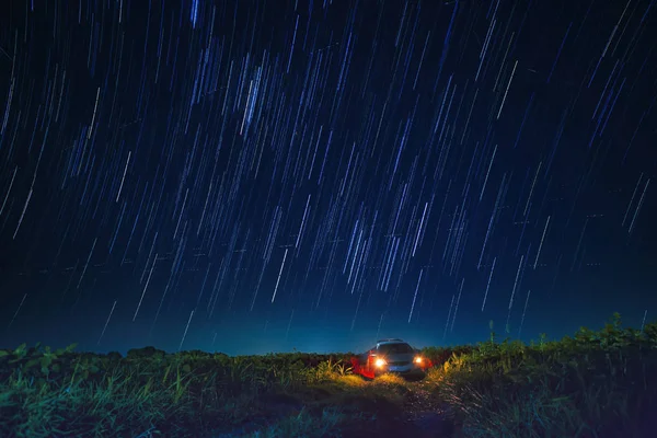 Noční scéna hvězda ocasu a modrá obloha nad parkoviště v zemědělské budovy — Stock fotografie