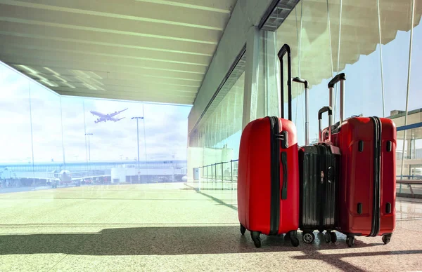 stack of traveling luggage in airport terminal and passenger pla