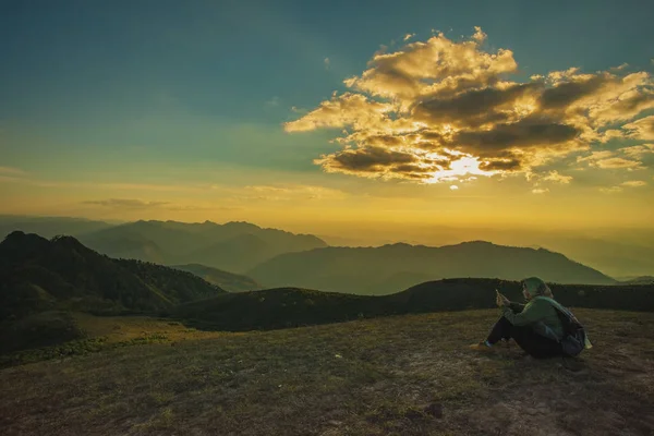 Trekingové žena uvolňující na vrcholu hory proti krásné slunce — Stock fotografie