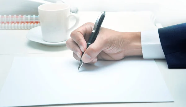 Mano del hombre de negocios escribiendo en papel blanco — Foto de Stock