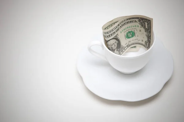 Jeden dolarů bankovek v šálku kávy — Stock fotografie