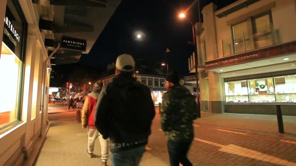 QUEENSTOWN NUEVA ZELANDA - 28 de agosto: turista caminando por la carretera por la noche en el centro comercial de Queenstown destino turístico más popular en la isla del sur en agosto 28,2015 en Queenstown Nueva Zelanda — Vídeo de stock