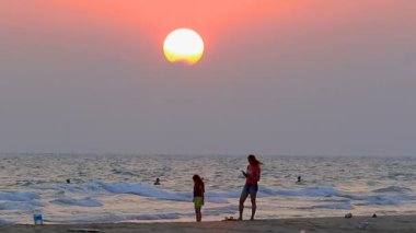 Rayong Tayland - Nisan 11,2016: mae rumphub seabeach en popüler hedef üzerinde duran ve yanında güzel günbatımı gökyüzü karşı smartphone bir fotoğraf çekici kadın 