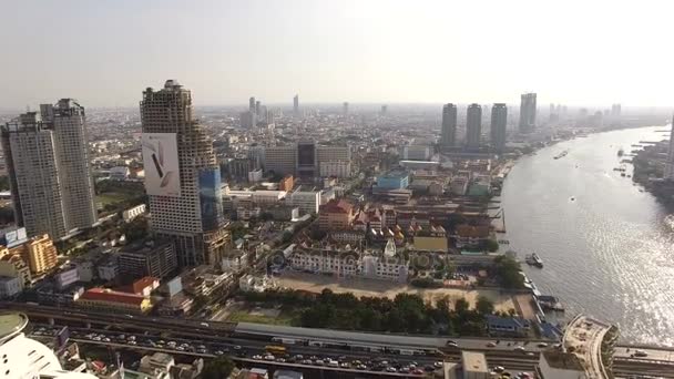 BANGKOK THAILAND - DEZEMBRO 24,2015: visão aérea drone tiro de chao praya rio e ponte de sathorn no coração da capital tailandesa, estrada de sathorn é rua do moderno edifício de escritórios de trabalho — Vídeo de Stock