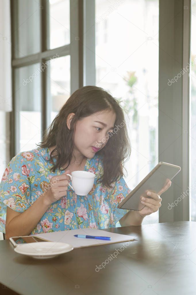 asian younger woman reading news from social media and other han