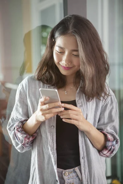 Retrato de hermosa asiática joven mujer leyendo mensaje en sma — Foto de Stock