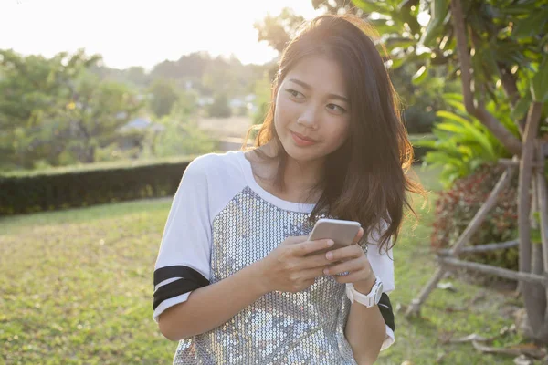 Νεότερος γυναίκα της Ασίας με το smartphone στο χέρι ευτυχία σκέψης , — Φωτογραφία Αρχείου
