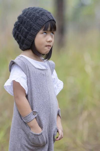 Wajah lucu gadis asia berdiri di lapangan dengan hijau kabur backg — Stok Foto