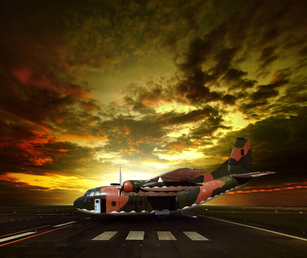 военный самолет на взлетно-посадочной полосе аэропорта против красивого солнца

