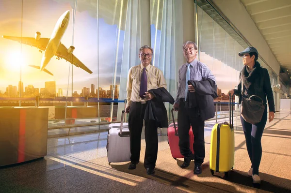 Zwei Geschäftsleute und eine Frau mit Reisegepäck in der Luft — Stockfoto