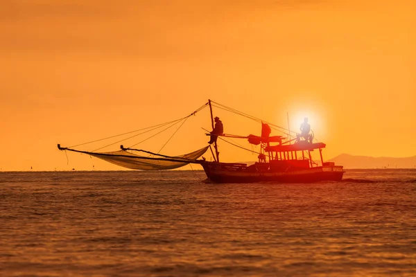 Silhouette fotografi av fiske båt och solnedgång himlen över havet h — Stockfoto
