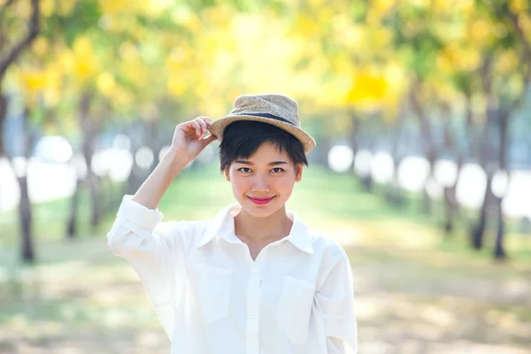 Porträt einer schönen asiatischen Frau, die in blühenden Blumen steht — Stockfoto