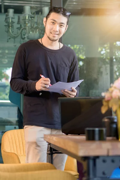 オフの家で笑顔で立っている若いアジア フリーランス男 — ストック写真
