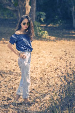 Asyalı kadın model poz için moda fotoğrafçılığı kuru yapraklar üzerinde 